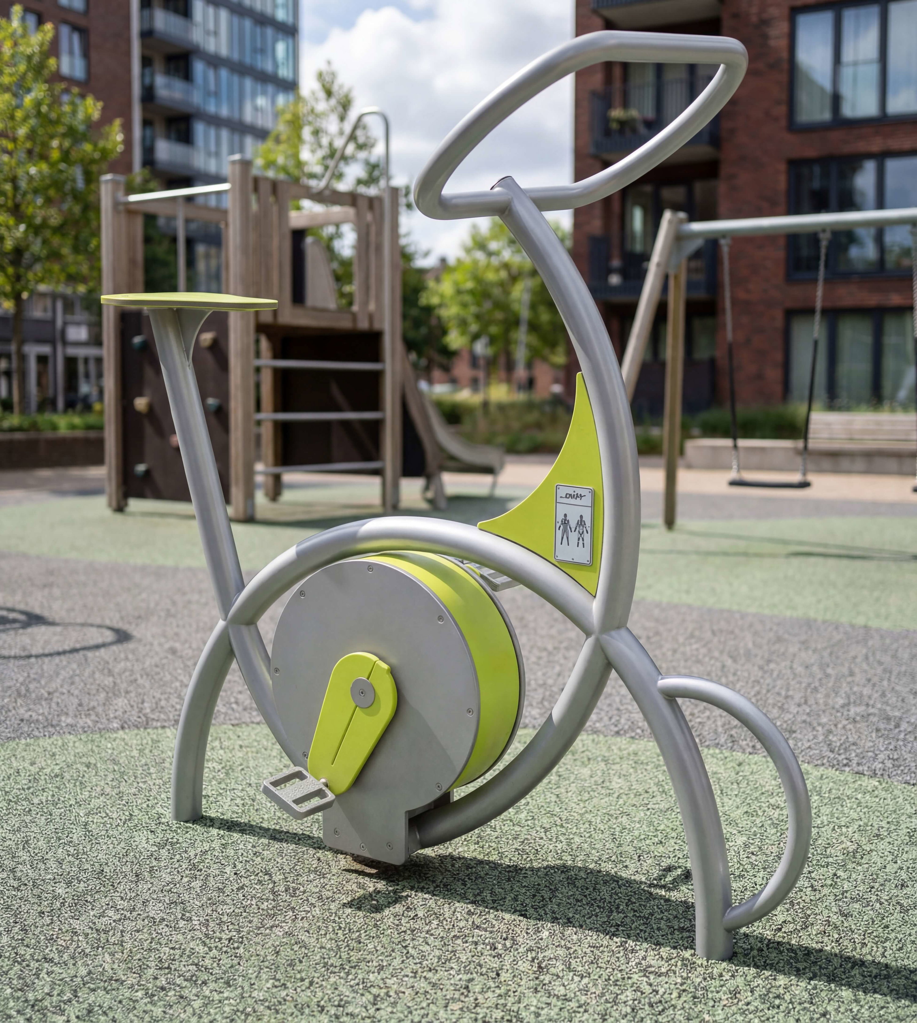 Gelber Fitness- und Spielgerät im städtischen Park vor Wohnhäusern unter blauem Himmel.