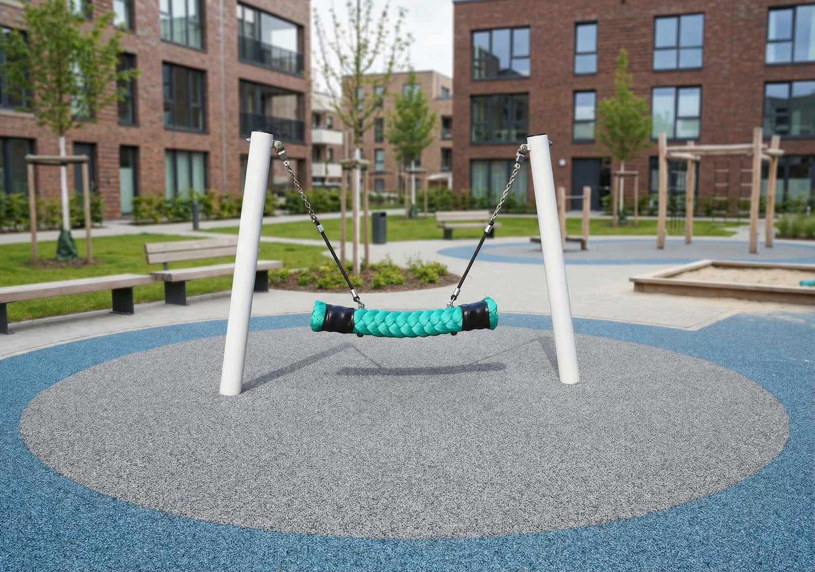 Ein türkisfarbenes Schaukelgerät auf einem blauen und grauen Spielplatz vor modernen Wohnhäusern.