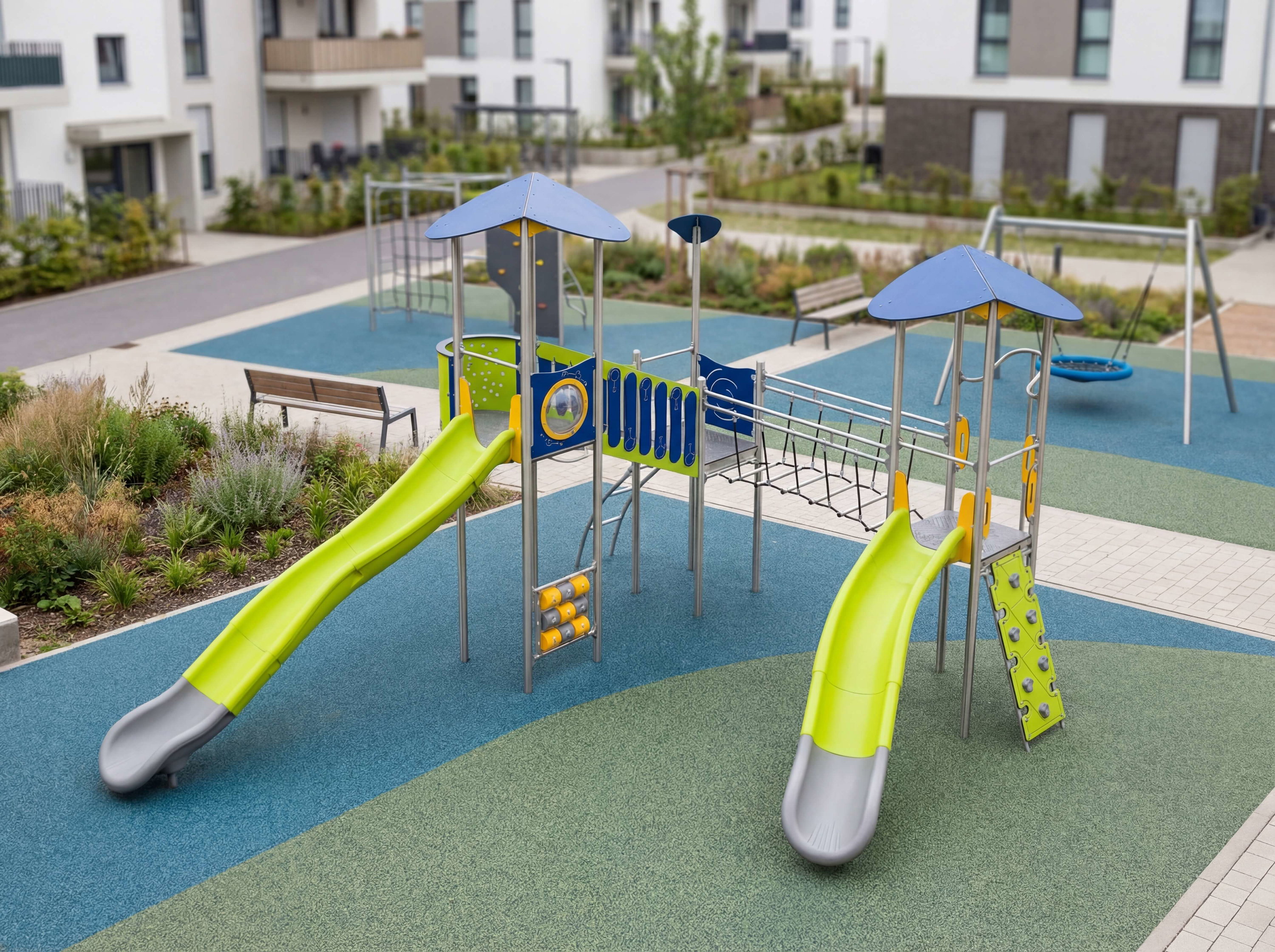 Farbiger Spielplatz mit Rutschen und Klettergerüst vor modernen Wohnhäusern.