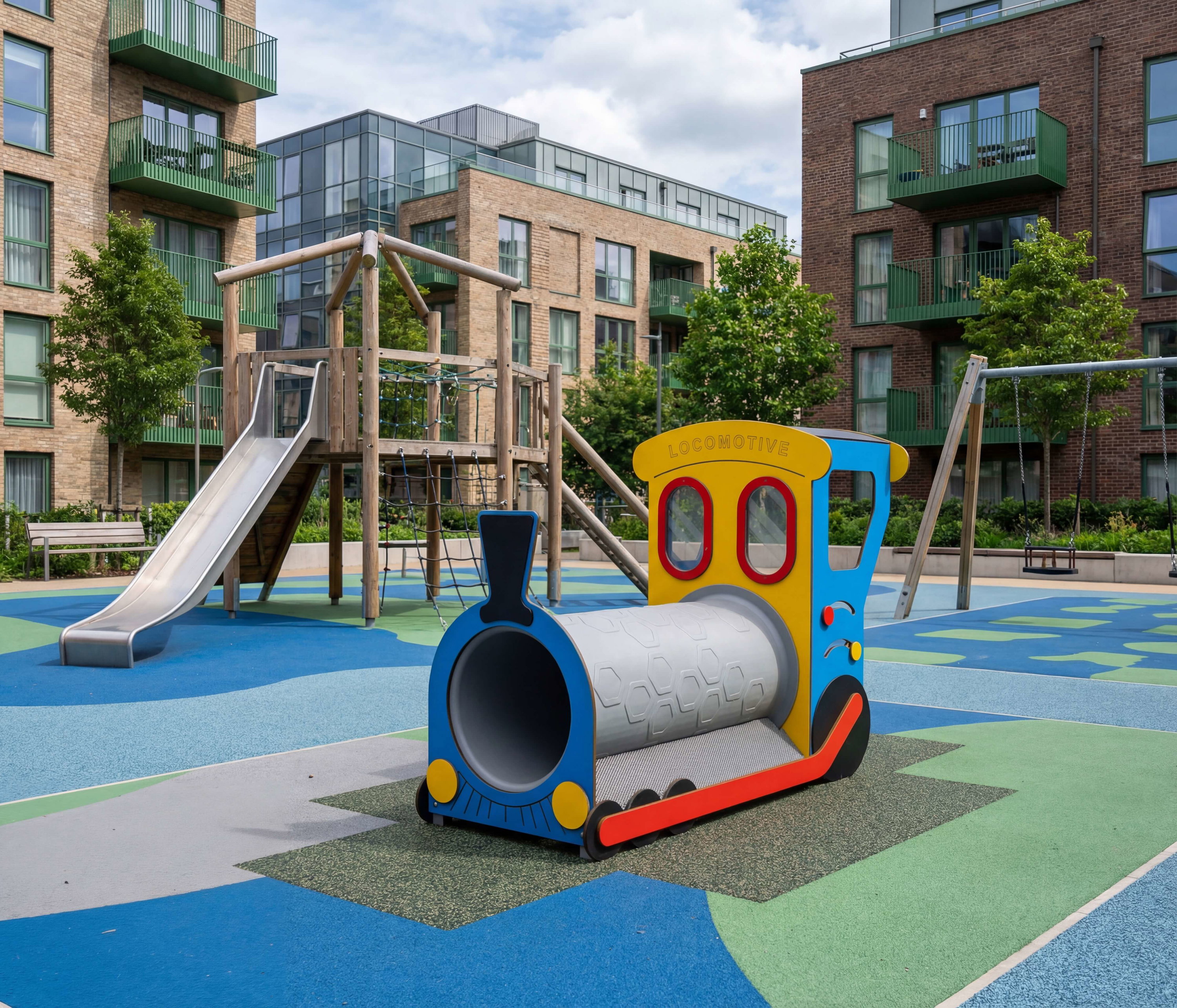 Bunte Spielplatz mit Dampflok-Spielzeug und Rutschanlagen vor modernen Wohnhäusern.