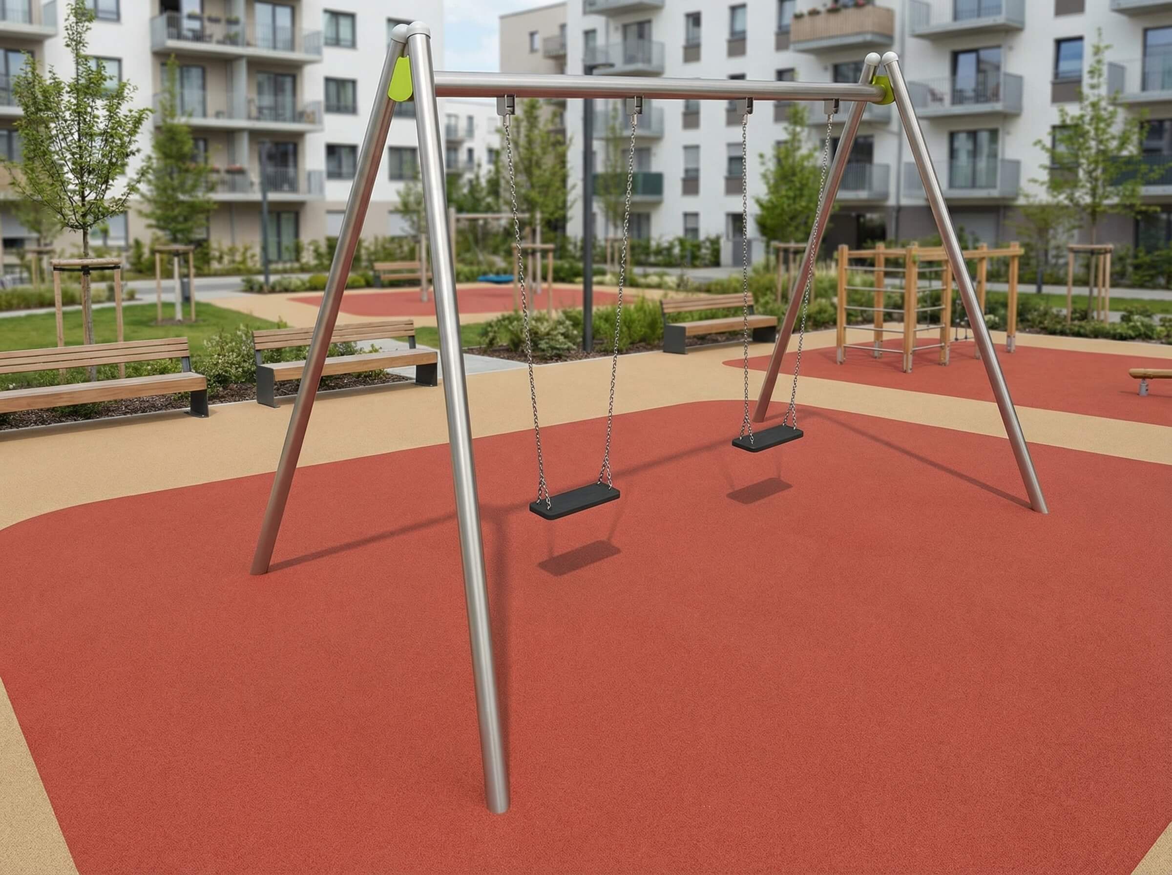 Schaukeln im modernen Spielplatz vor Wohnhäusern mit rotem Bodenschutz und Bänken.