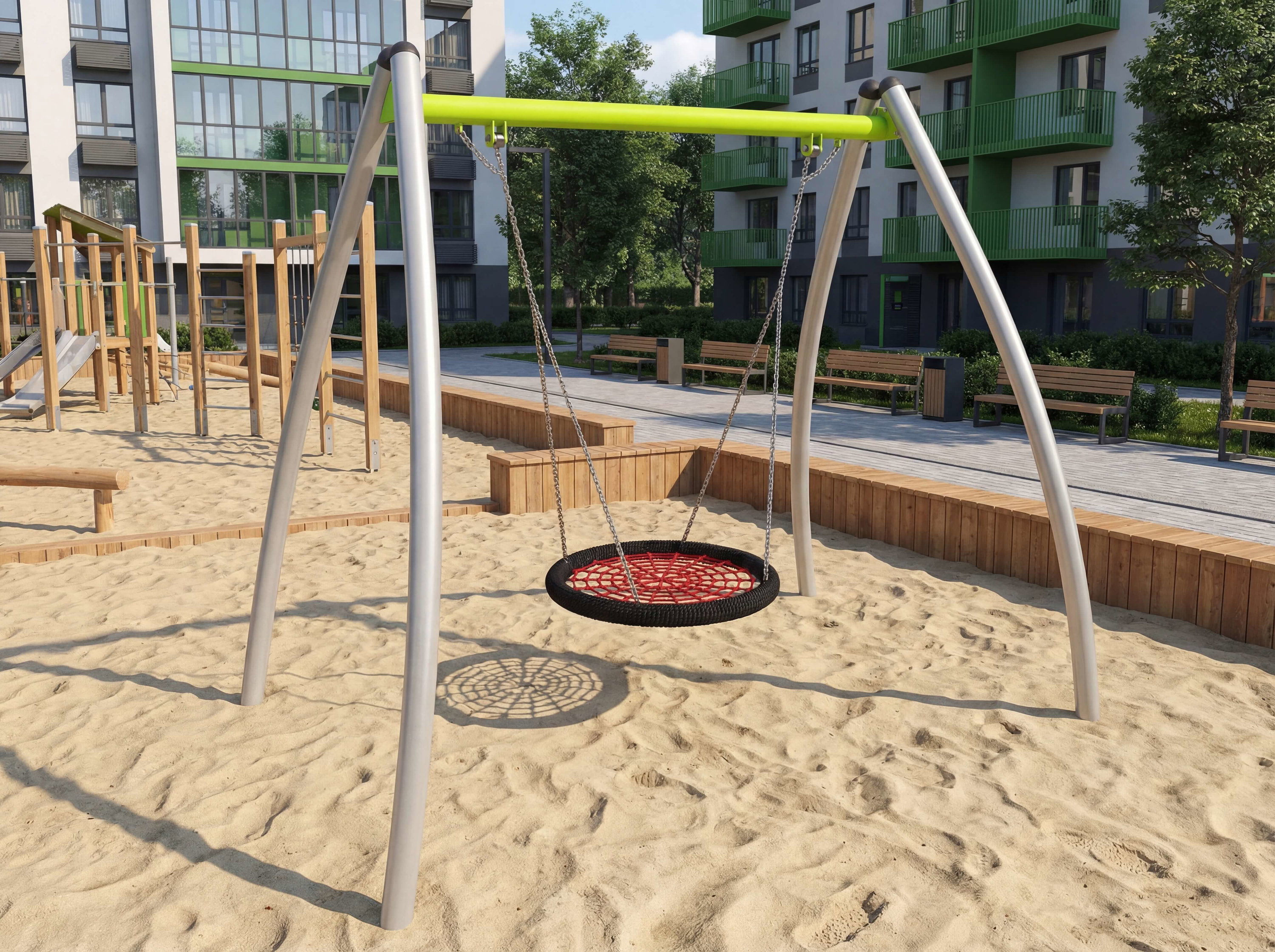 Spielplatz mit Rundschaukel im Sand vor modernen Wohnhäusern.