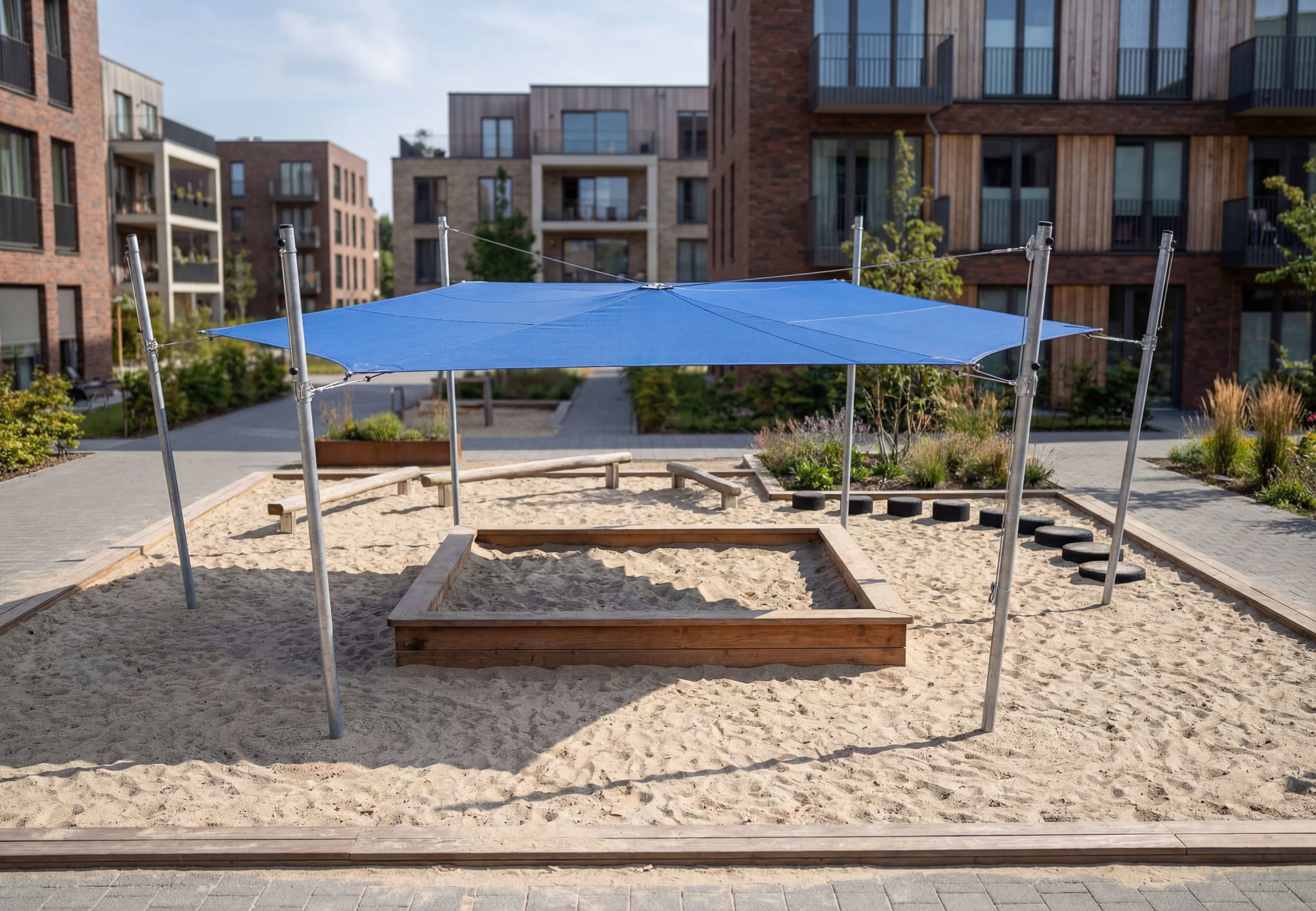 Blauer Schattenspender über Sandkasten im modernen Wohnbereich mit Holz- und Backsteinhäusern.