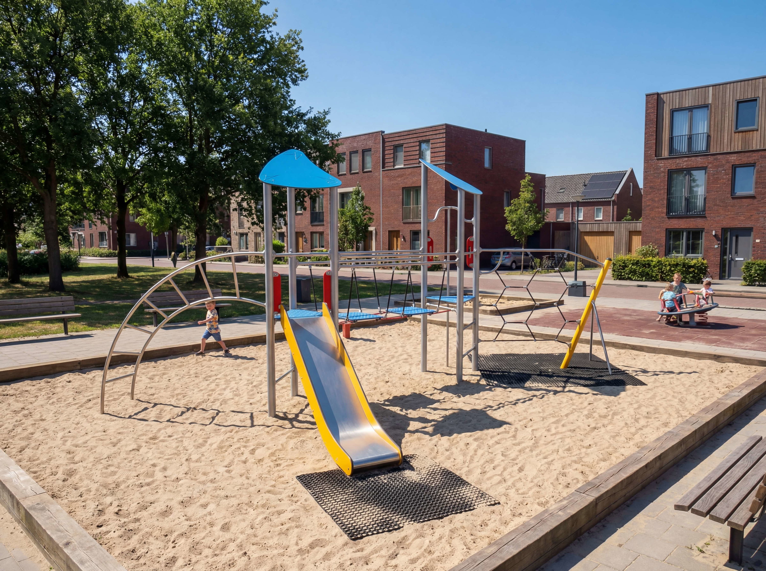 Kinder spielen auf einer modernen Sandkletteranlage vor Wohnhäusern unter blauem Himmel.