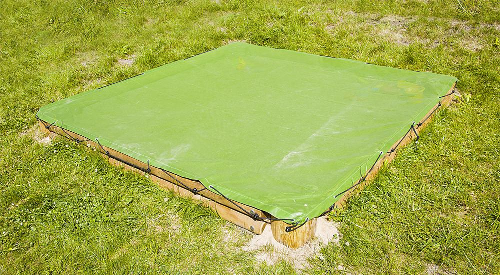 Grünes Pool-Deck auf Holzrahmen im Gras liegend – Outdoor-Schwimmbadabdeckung