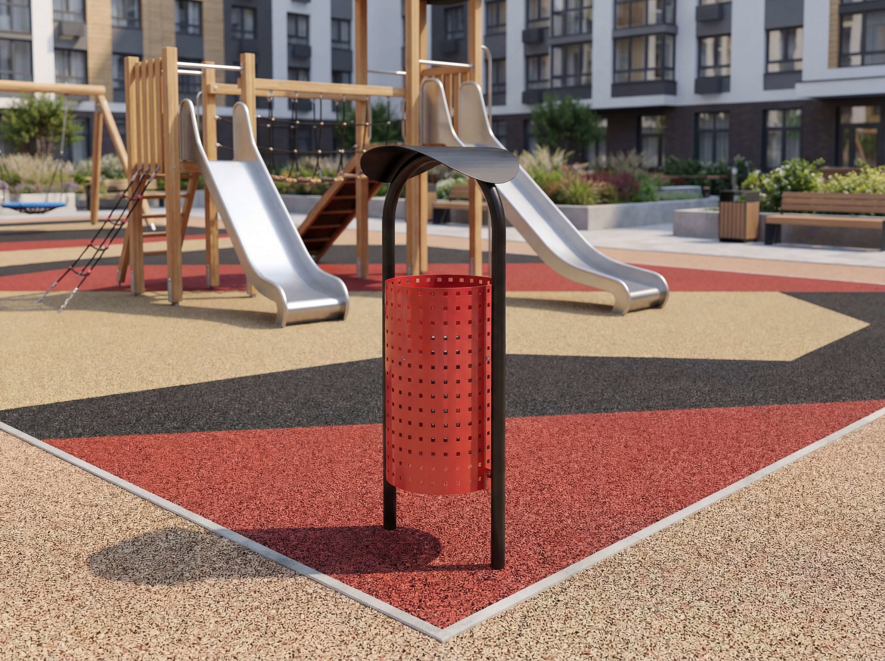 Roter Mülleimer im modernen Spielplatz vor Wohngebäuden mit Rutschröhren und Sandkasten.