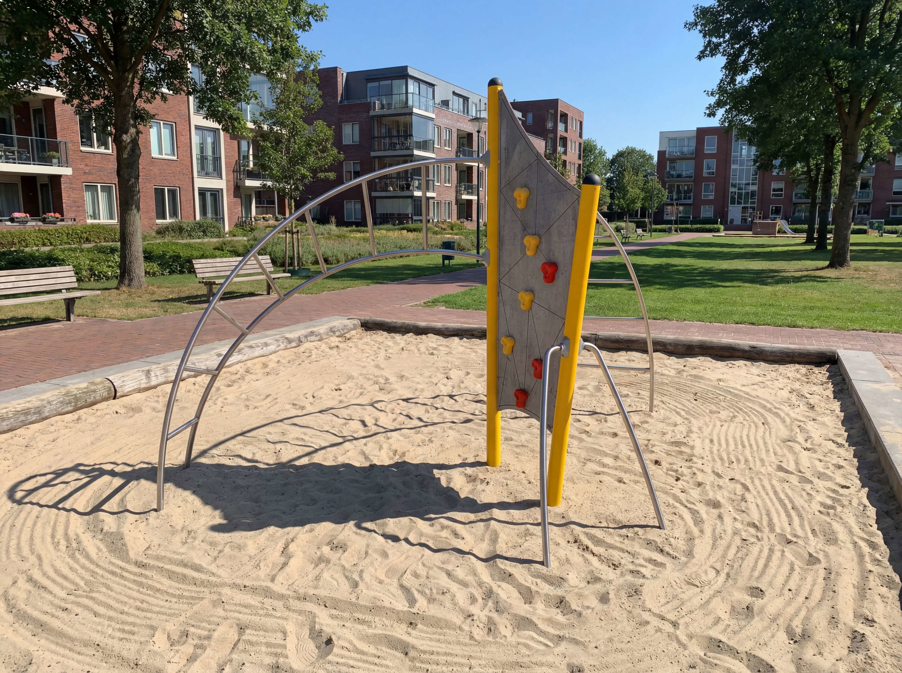 Spielplatz mit Kletterwand und Sandkasten im sonnigen Wohngebiet.