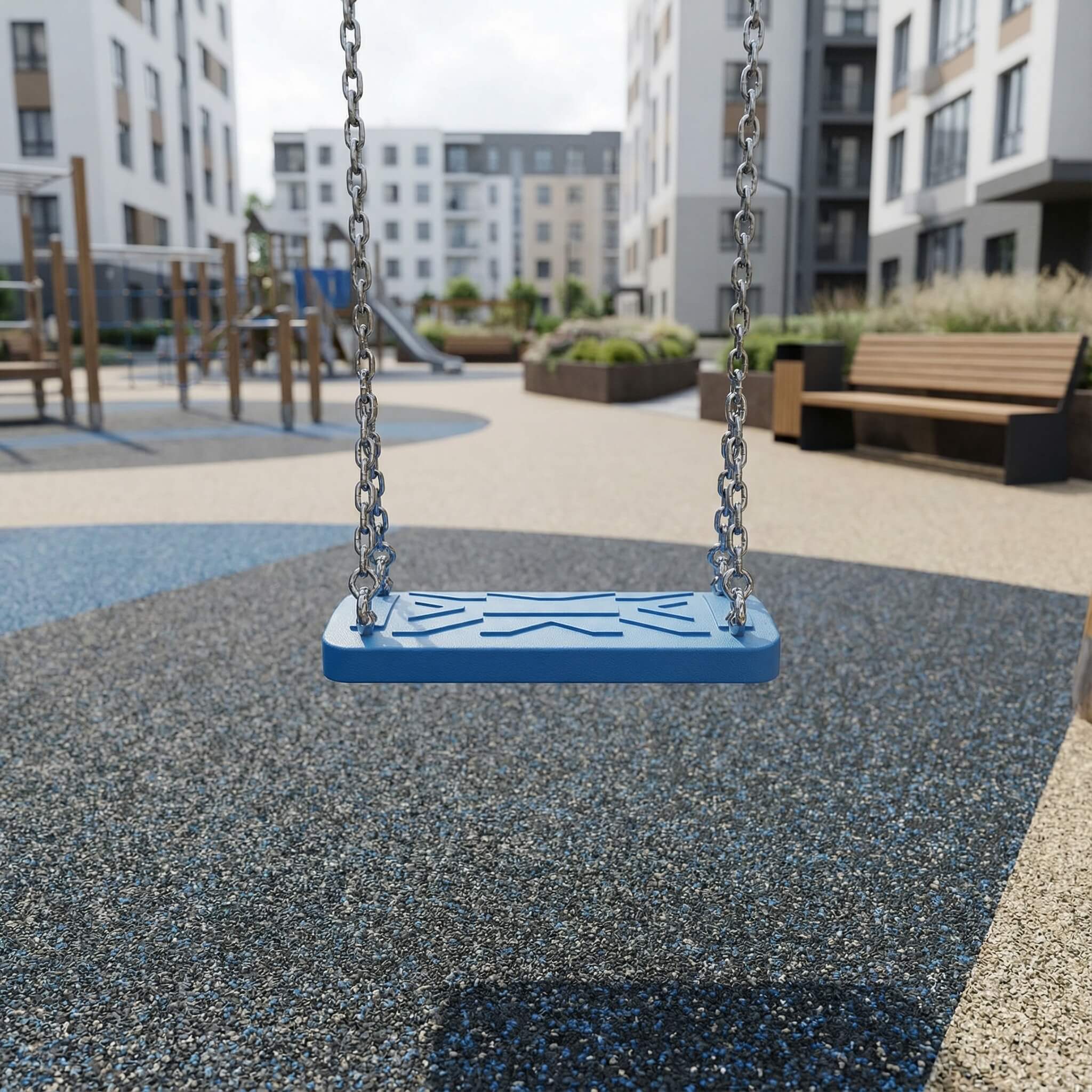 Blauer Schaukelstuhl im modernen Spielplatz vor Wohngebäuden mit gepflastertem Boden.