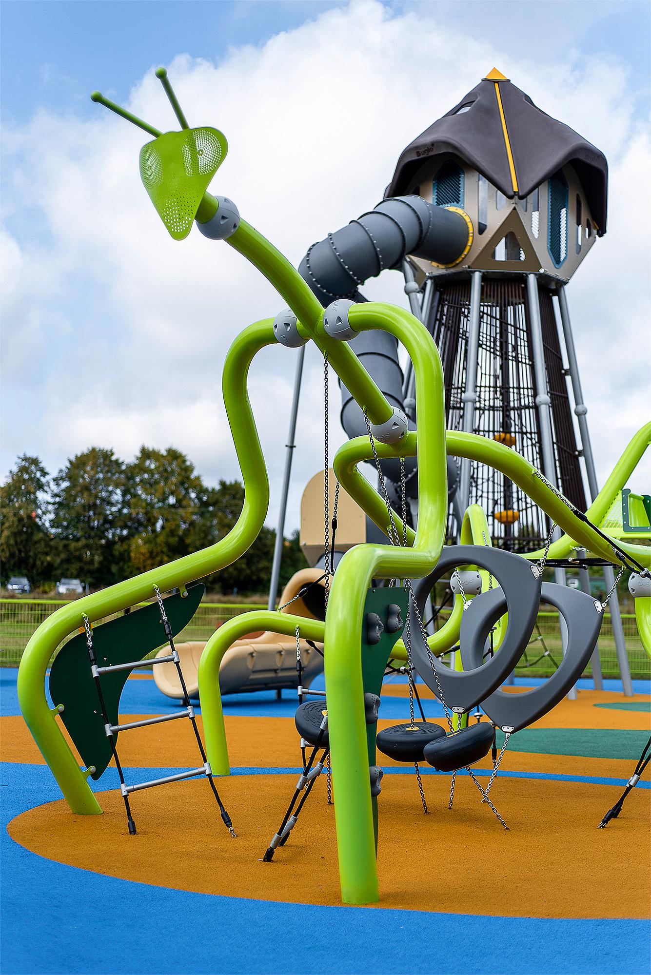 Farbiger Spielplatz mit Giraffen- und Turmstrukturen unter blauem Himmel.