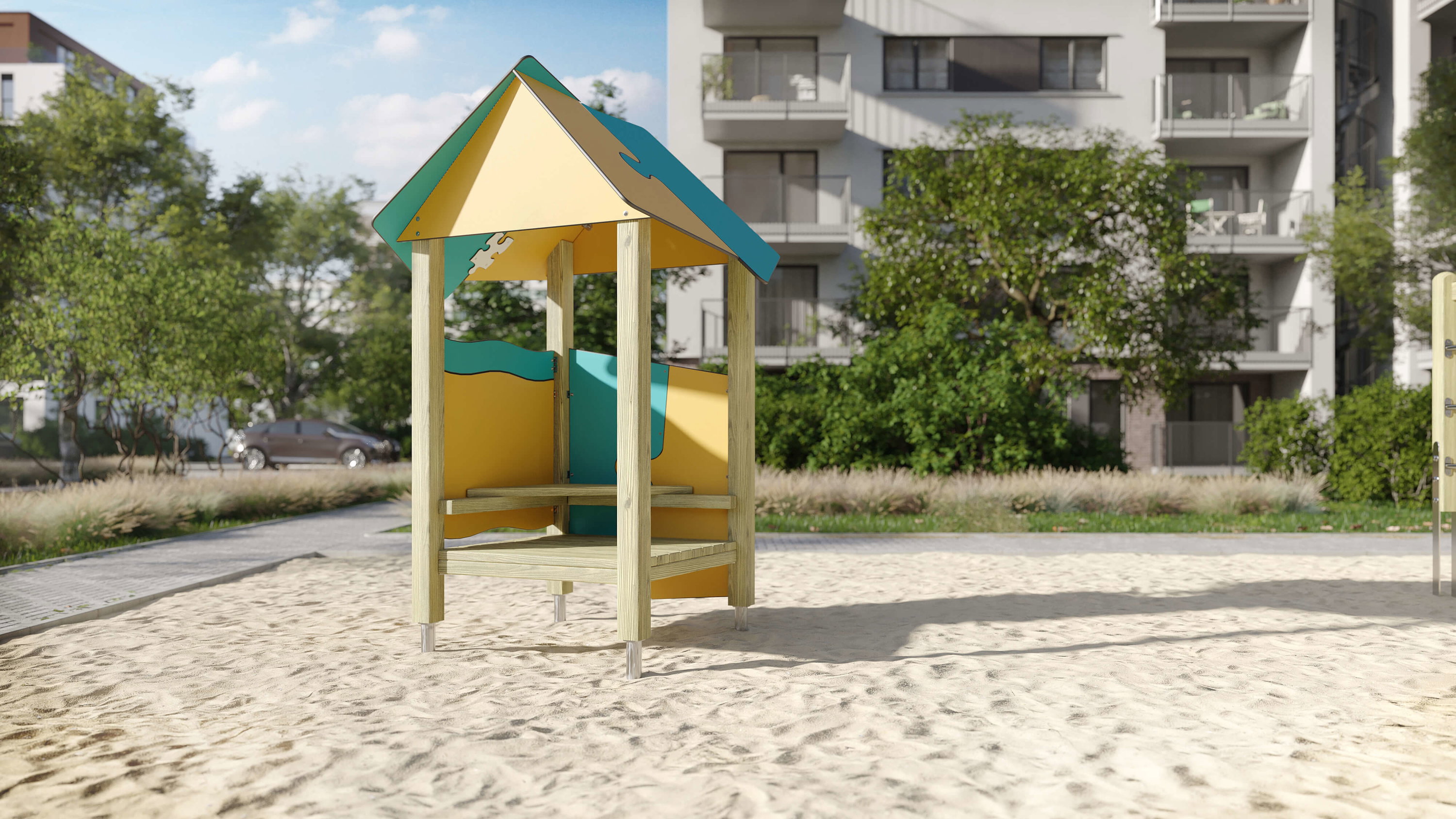 Bunte Spielhütte im Sand auf einem modernen Wohnplatz mit Bäumen und Gebäuden im Hintergrund.